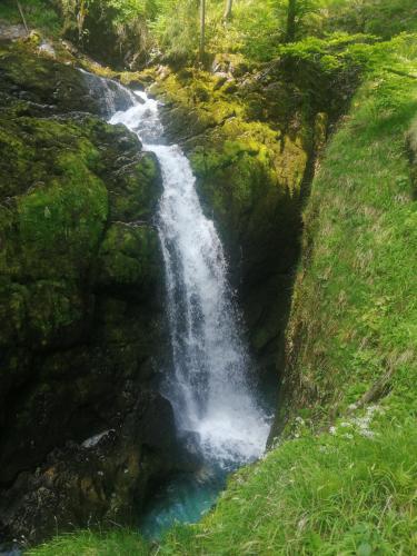a waterfall on the side of a hill with green grass at Ferienhaus Krallinger in Abtenau