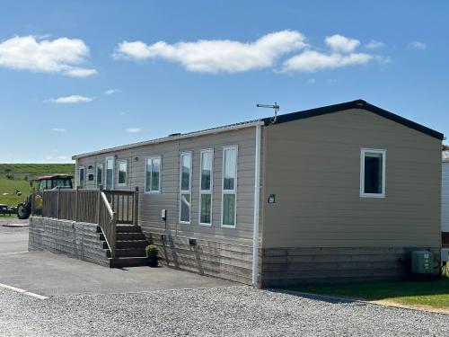 a small building with a staircase in front of it at Luxury Lake District Holiday Lodge-Sleeps 4 in Cockermouth