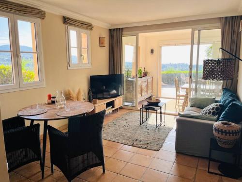 sala de estar con mesa y sofá en Vue panoramique mer et collines, en Grimaud