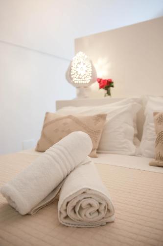 a white bed with two white towels on it at Masseria Parco della Grava in Pezze di Greco