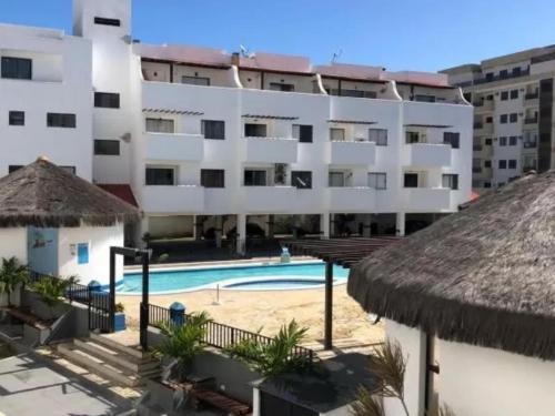 un hotel con piscina frente a un edificio en Villa da Praia Resort - Orla Praia Grande, en Arraial do Cabo