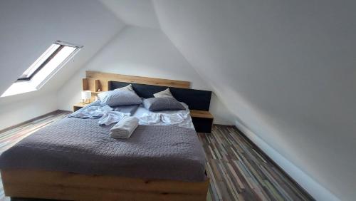 ein Schlafzimmer mit einem Holzbett mit blauen Kissen in der Unterkunft Casa nouă in Sasca Montană