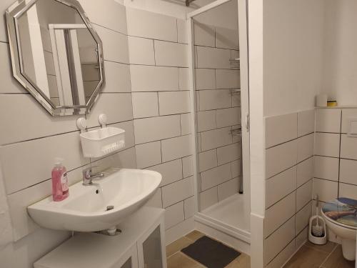 a white bathroom with a sink and a mirror at A&B1 in Rudolstadt