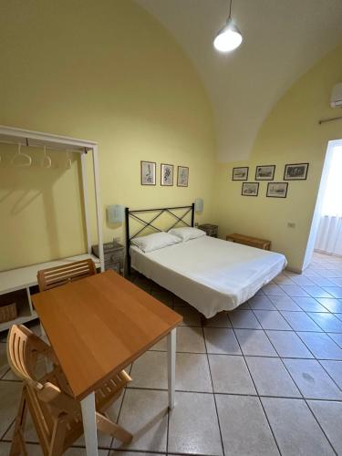 a bedroom with a bed and a wooden table at Anfiteatro in Formia