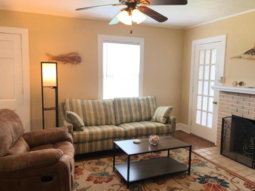 a living room with a couch and a fireplace at Calypso Pensacola in East Hill Neighborhood ! in Pensacola