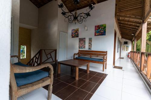 sala de estar con mesa, sillas y lámpara de araña en Galeria & Suites Canto do Sol en Barra Grande
