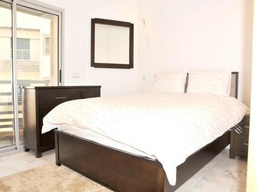 een slaapkamer met een groot bed en een spiegel bij Beverly Hills California in Kenitra