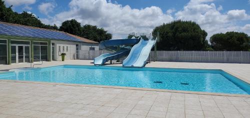 a pool with a water slide in a yard at Mobil Home 5 pers 1 Km de l'Océan in Talmont