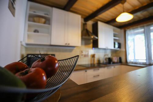 a bowl of tomatoes sitting on a counter in a kitchen at Szum Muzy Ruś Mała in Ostróda