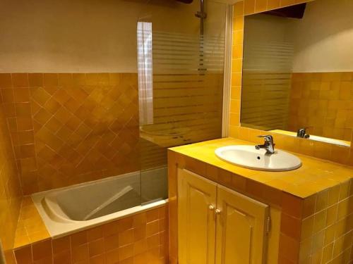 uma casa de banho com um lavatório e uma banheira em Maison de village 3 chambres avec petite terrasse em Ramatuelle