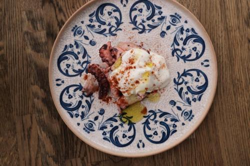a blue and white plate with food on a table at W Costa Navarino in Pylos