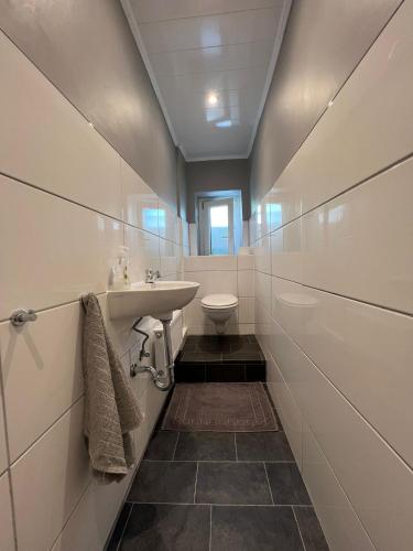 a bathroom with a sink and a toilet at Eva's Hostel - Self Check-In & Only Private Rooms in Düsseldorf