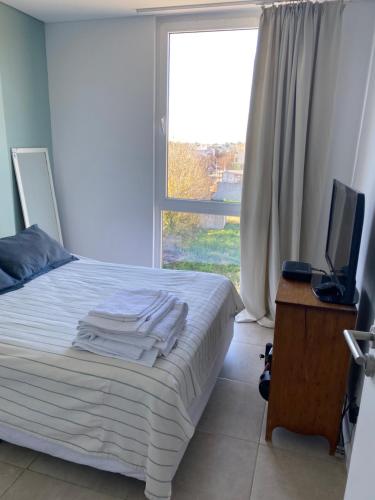a bedroom with a bed with a television and a window at Pinto 32 in Tandil