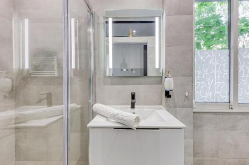a bathroom with a white sink and a shower at Porte de PARIS , Métro 10 minute à pied Parking gratuit wifi gratuit Netflix in Le Kremlin-Bicêtre