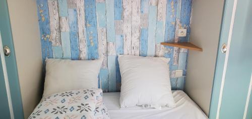 - un lit avec deux oreillers dans l'établissement Mobil Home 5 pers 1 Km de l'Océan, à Talmont-Saint-Hilaire