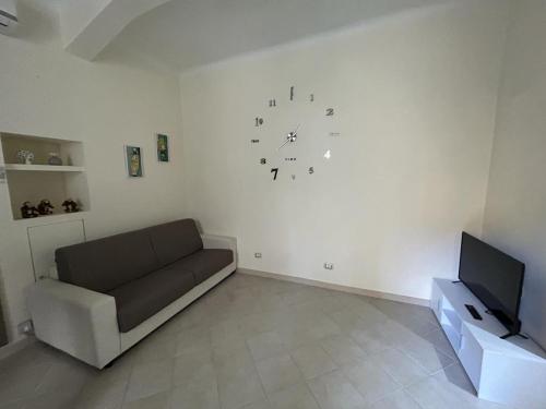 ein Wohnzimmer mit einem Sofa und einer Uhr an der Wand in der Unterkunft Casa Bezzecca La Spezia in La Spezia