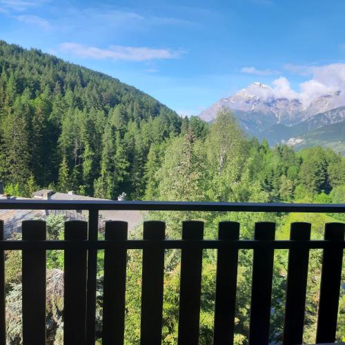 a view of the mountains from a fence at Appartamento con vista - nuova ristrutturazione in Sauze dʼOulx