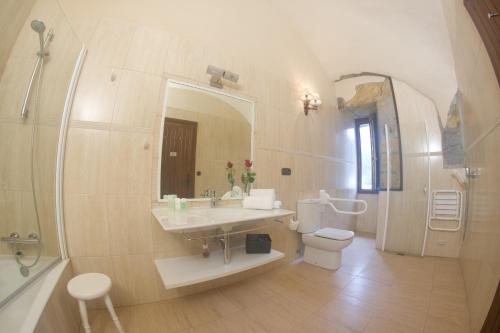 a bathroom with a sink and a toilet and a mirror at Hotel Larrañaga in Azpeitia