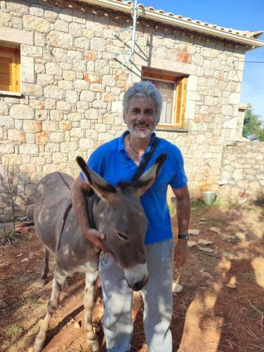 a man is standing next to a donkey at Stella Rooms in Kardamili