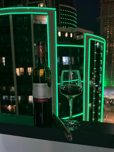 a bottle of wine and a glass on a table at Moonlight Apart-Hotel Batumi in Batumi