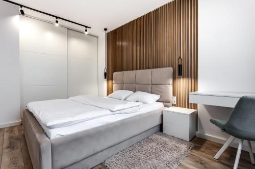 um quarto com uma cama, uma secretária e uma cadeira em VIP Apartments em Lviv