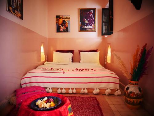 Un dormitorio con una cama con una bandeja de comida. en SARDINAS & CHILI en Marrakech