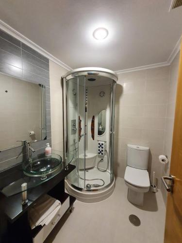 a bathroom with a glass shower and a toilet at Mirador de Barreiros in Barreiros