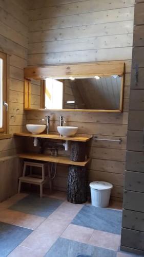 une salle de bain avec deux lavabos et un miroir dans l'établissement Chalet le Brame en Cevennes, à Camprieu