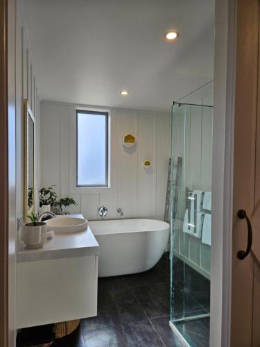 uma casa de banho branca com uma banheira e um lavatório em Templeton's Stone stay em Twizel