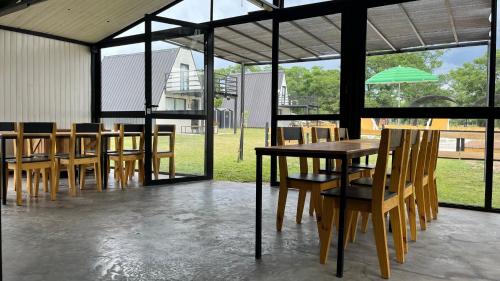 a group of wooden tables and chairs with an umbrella at COMPLEJO ISABELLA in Villa Amancay
