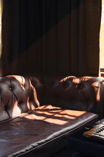 a brown leather couch sitting in a living room at Panorama Ushba in Mestia