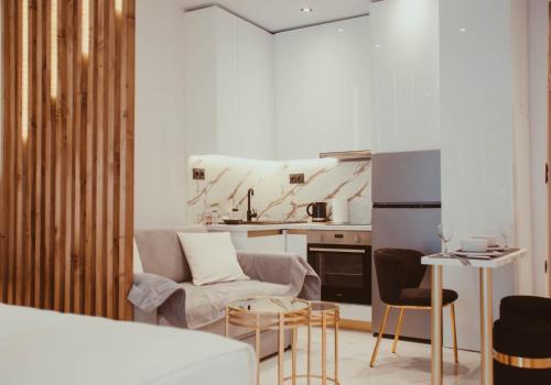 uma sala de estar com um sofá e uma cozinha em Aelia - Luxury Central Suite em Alexandroúpolis
