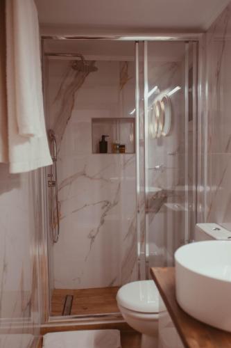 a bathroom with a shower and a toilet and a sink at Aelia - Luxury Central Suite in Alexandroupoli