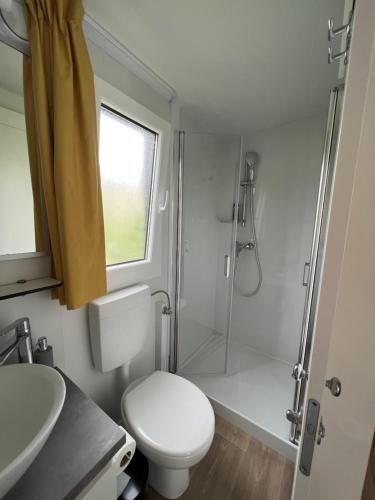 a bathroom with a shower and a toilet and a sink at LunaBay SpiritoS Mobile Home, Terra Park SpiritoS in Kolan