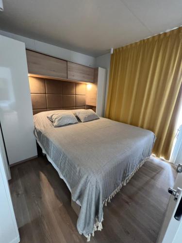 sypialnia z dużym łóżkiem i oknem w obiekcie LunaBay SpiritoS Mobile Home, Terra Park SpiritoS w mieście Kolan