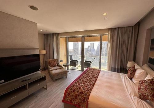 a hotel room with a bed and a flat screen tv at Luxe - Fashion Avenue Dubai Mall - Formerly Address Dubai Mall in Dubai