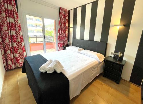 1 dormitorio con 1 cama grande y toallas. en ALMA BEACH ESTARTIT en L'Estartit