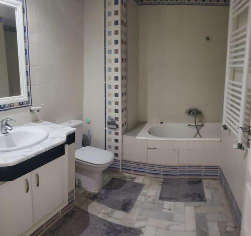 e bagno con vasca, servizi igienici e lavandino. di Appartement en bord de mer a Monastir
