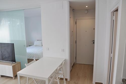 a white room with a white table and a bed at Centro Sitges in Sitges