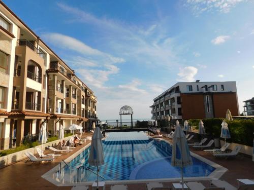 a pool at a hotel with umbrellas and chairs at Azzurro Sarafovo in Burgas City