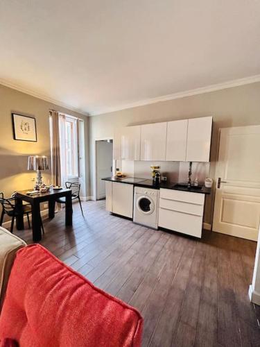 une cuisine avec des armoires blanches et une table dans une pièce dans l'établissement Appartement COSY centre Ajaccio, à Ajaccio