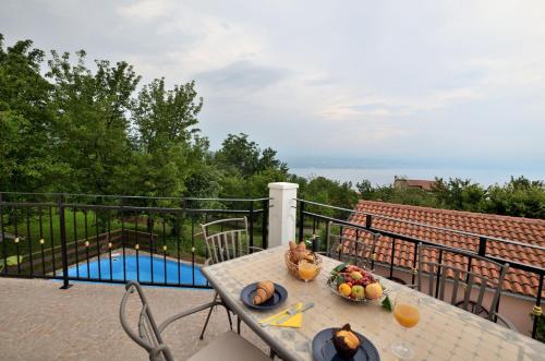 een tafel met een fruitschaal op een balkon bij House Aronia in Lovran