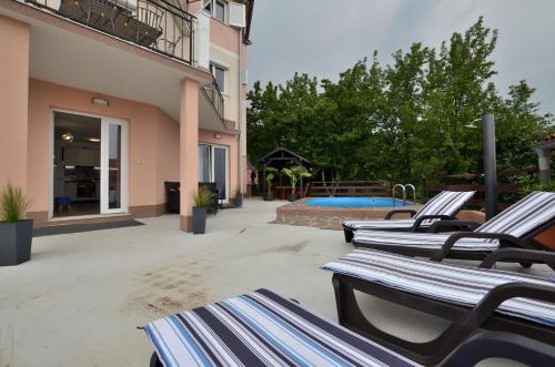 een rij ligstoelen naast een zwembad bij House Aronia in Lovran