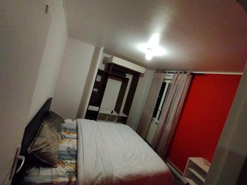 - une petite chambre avec un lit et une porte rouge dans l'établissement Ben heber, à Sotteville-lès-Rouen