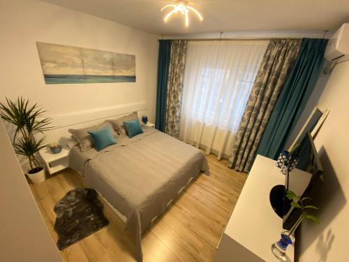 1 dormitorio con cama, escritorio y ventana en JACOBS LUXURY Apartaments en Râmnicu Vâlcea