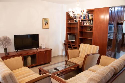 - un salon avec un canapé et une télévision dans l'établissement Luxury Apartment, near Pinikoudes beach, à Larnaka