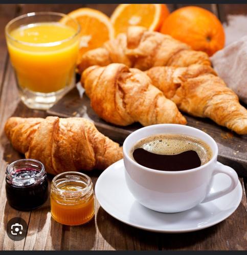 - une tasse de café, des croissants et des oranges sur une table dans l'établissement Ben heber, à Sotteville-lès-Rouen