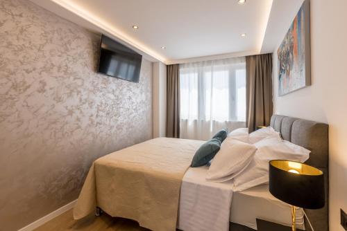 een slaapkamer met een bed en een televisie aan de muur bij The little Prince in Split
