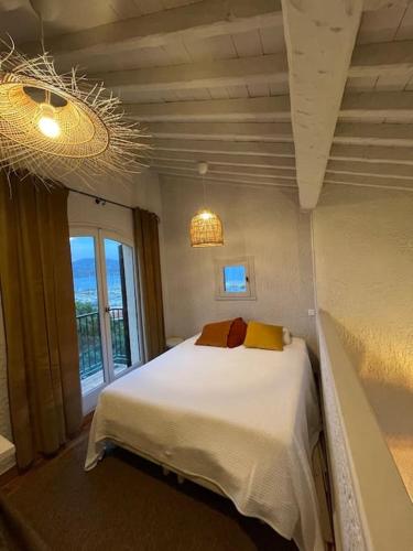 une chambre avec un lit et une grande fenêtre dans l'établissement les Marines de cogolin, Brigantine, à Cogolin