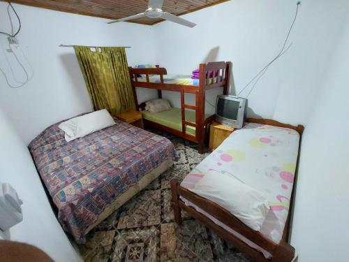 1 dormitorio con 2 camas y TV pequeña en Alquiler Temporario en Puerto Iguazú en Puerto Iguazú